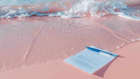 Contract and a pen laying on a beach in Bermuda