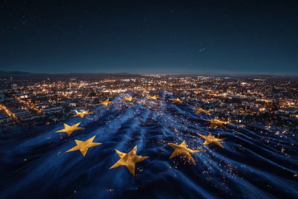 city landscape lit up at night overlaid by a semi-transparent EU flag pattern
