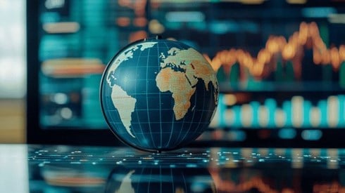 A globe in front of various graphs
