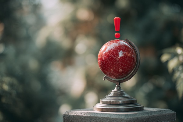 A red globe with a red exclamation point above it