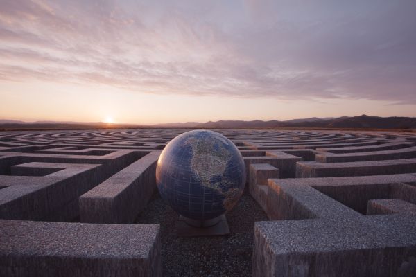 globe of the earth inside a concrete maze at sunrise