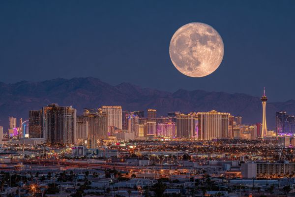 oversized full moon rising over the Las Vegas skyline at night