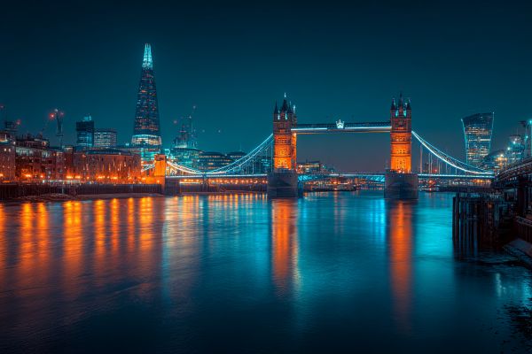 London Tower Bridge and River Thames lit up in blues and oranges at night