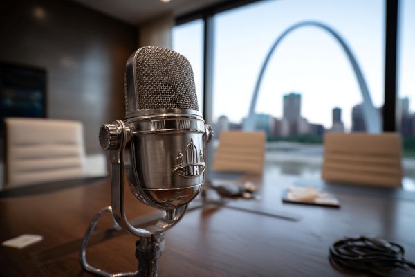 podcast microphone on a conference table beside a window overlooking the St Louis Arch