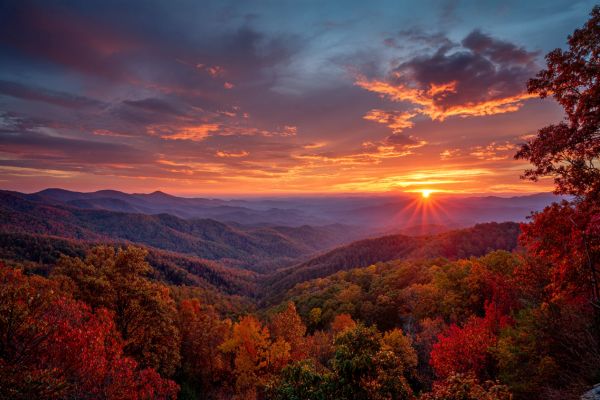 warm colorful sunrise over the Tennessee mountains during fall with red, yellow, and orange leaves