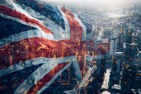 UK flag waving digitally superimposed over an overhead view of London