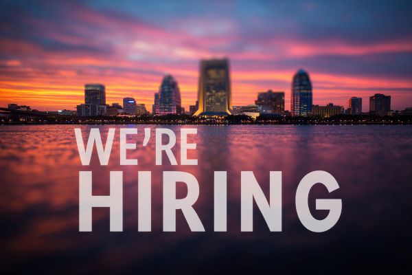 the words "We're Hiring" in white superimposed over a coastal view of Charleston, South Carolina at sunset
