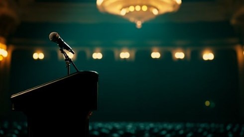 microphone on a podium in an auditorium with a large chandelier