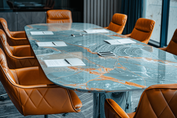 Marble table surrounded by leather chairs with documents on top of the table