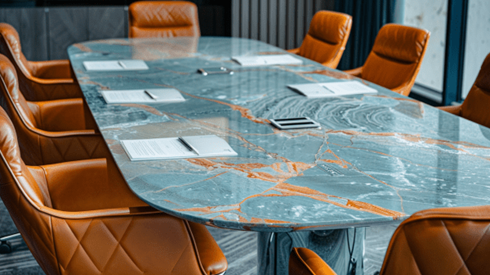 Marble table surrounded by leather chairs with documents on top of the table