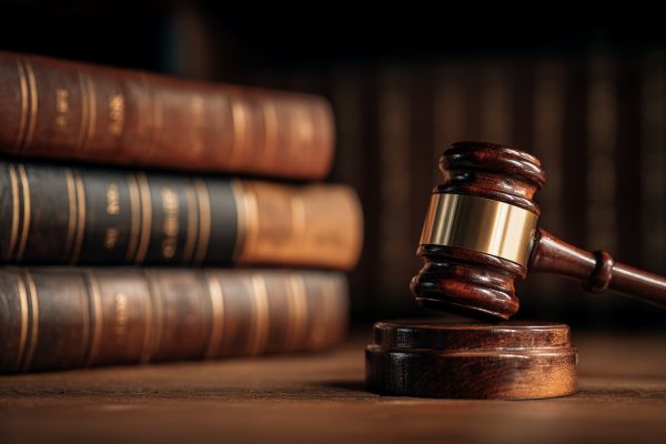 gavel in front of a stack of old legal books 