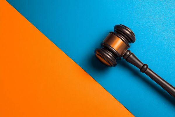 legal gavel lying on a blue and orange diagonally split background