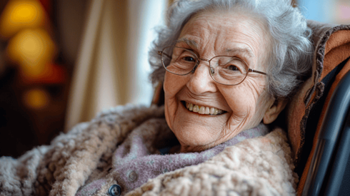 An elderly woman smiles while seated