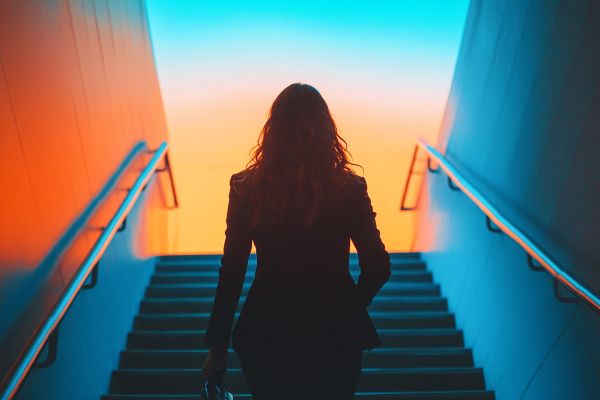 Business woman walking up blue stairs