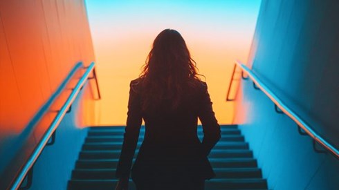 Business woman walking up blue stairs