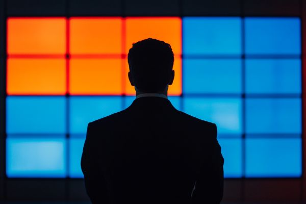 silhouette of a businessman in front of a blue and orange screen