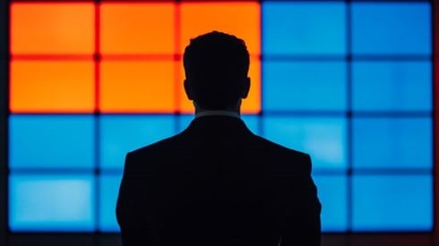 silhouette of a businessman in front of a blue and orange screen