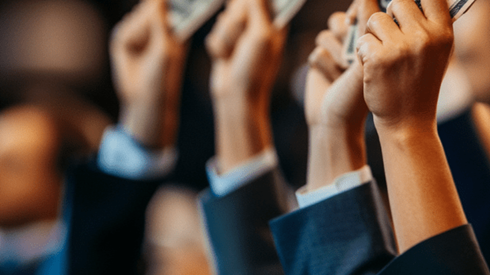 Businesspeople in suits holding up money