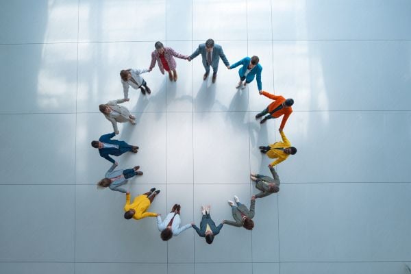overhead view of businesspeople holding hands in a circle