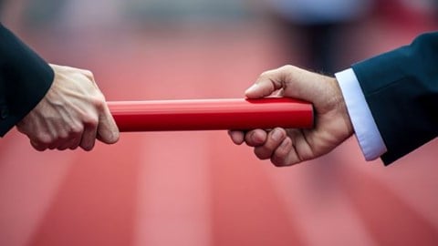 businessperson passing a baton to a second person over a race track