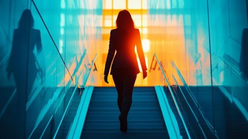 businesswoman walking up blue stairs into the sun