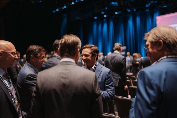 A group of businesmen gathered in agroup and talking at a conference