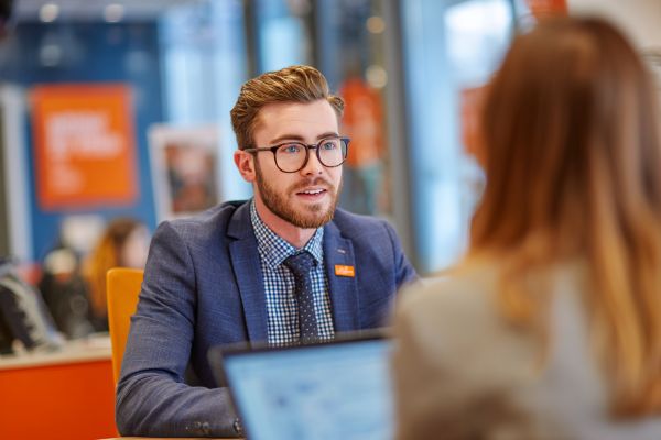young businessman sitting across from an interviewer in a modern business office