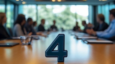 The number four on a conference table that is surrounded by businessmen and businesswomen talking to each other