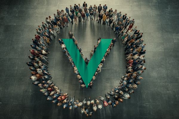 overhead view of businesspeople in a circle with some around a green V in the center