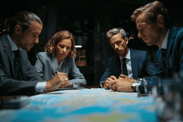 Four risk managers sitiing around a map discussing strategy