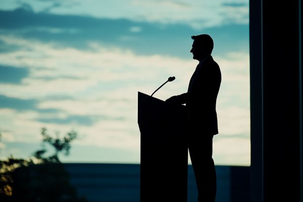 silhouette of businessman in front of a podium
