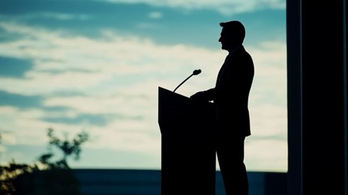 silhouette of businessman in front of a podium