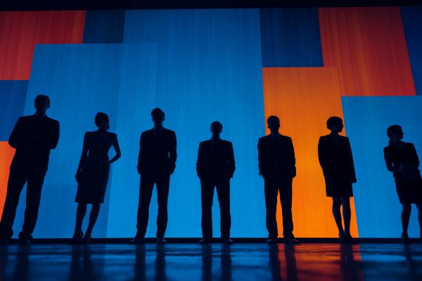silhouettes of approximately the same height businesspeople lined up in front of blue and orange screens