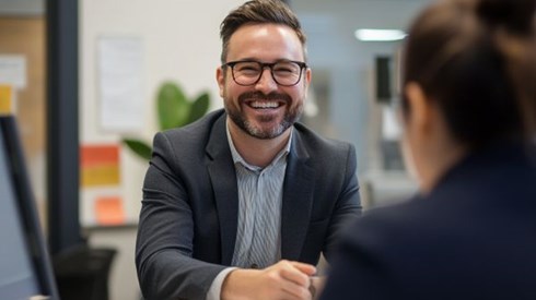 man smiling at a woman over an office desk