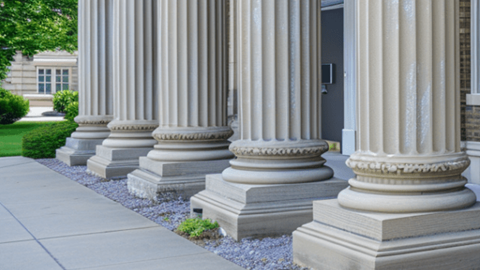 Five white stone columns in front of a building