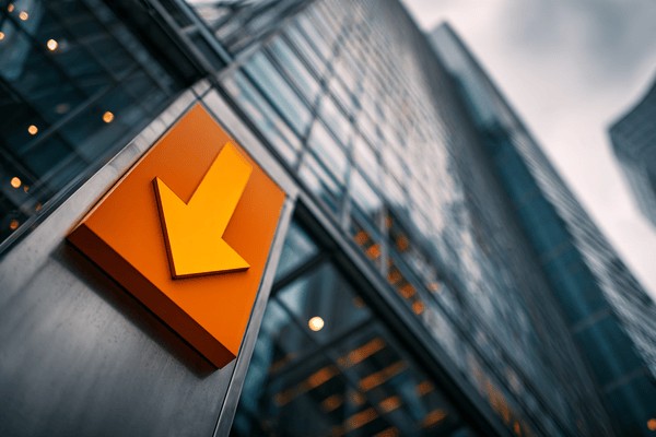 An orange arrow pointing down on the side of a glass skscraper
