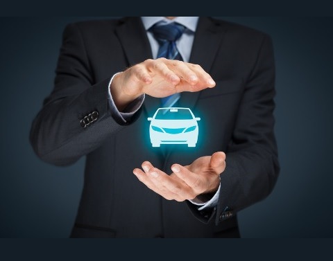 Businessman with his hands protecting a hologram of an auto