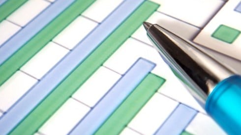 Bar chart with blue and green columns on white paper with blue pen pointing to a green bar