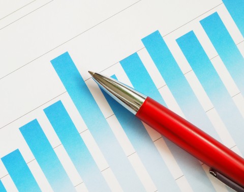 Red pen laying on a blue bar graph printed on a piece of white paper