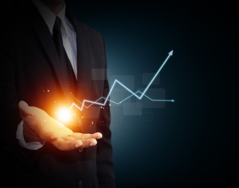 A man holds a hologram of an explosion and two graph lines marking high low points ending with arrows extending up and down