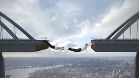 People hanging between gap in bridge