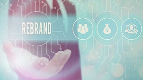Businessman holding the word "rebrand" and symbols for different business aspects