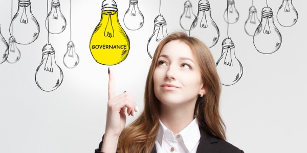 Business Woman Pointing At A Lightbulb That Says Governance