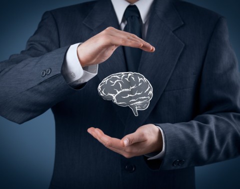Businessman protecting floating brain between his hands