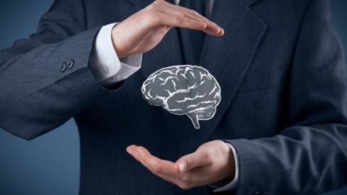 Businessman protecting floating brain between his hands