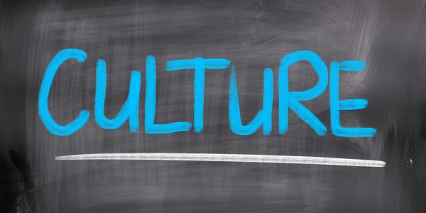 The word CULTURE written in blue chalk and underlined with a white line on a chalkboard with eraser marks
