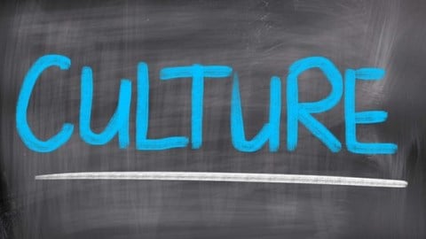 The word CULTURE written in blue chalk and underlined with a white line on a chalkboard with eraser marks