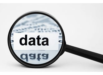 Out of a stack of labels with words and a magnifying glass focuses on the label with the word DATA