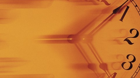 Clock face showing the hours 12 to 5 with the hands positioned at 4:03 and the rest blurred like it is moving fast