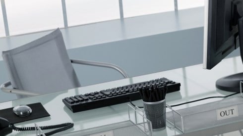 An empty modern style executive office with computer equipment and in and out boxes